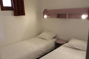 Cette chambre comprend 2 lits et une fenêtre. dans l'établissement Résidence Grand Bois A1118 Clés Blanches, à La Tania