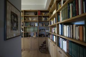 eine Bibliothek mit Holzregalen mit Büchern in der Unterkunft Ca' del Cuco in Barzana