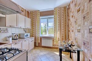 a kitchen with white cabinets and a table and a window at Apartment near the President's Park. Orbita-2 in Almaty