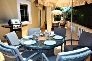 a table with chairs and an umbrella on a patio at Casa Roma in Almancil