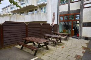 two picnic benches sitting outside of a building with an umbrella at Reykjavik Downtown Hotel in Reykjav&iacute;k
