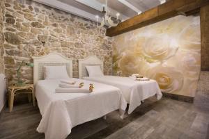 two beds in a room with a stone wall at Dulcelia Bilbao. Relax y confort en la ría .EBI-873 in Bilbao