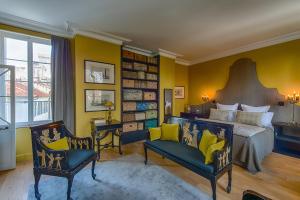 a bedroom with a king sized bed and a chair at La Divine Comédie-Suites Deluxe in Avignon