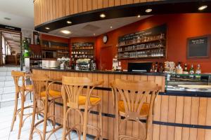 um bar com bancos de madeira num restaurante em Hôtel Restaurant Famille Bourgeois "La Cote des Monts Damnés" em Sancerre