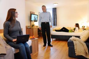 un hombre de pie en una sala de estar con una mujer en Hotel Christl, en Rohrdorf