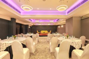 a conference room with white tables and chairs and purple lighting at IRA By Orchid Bhubaneswar in Bhubaneshwar