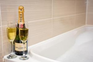 una bottiglia di vino e due bicchieri di champagne di Waterview Deluxe Apartments a Barrow in Furness