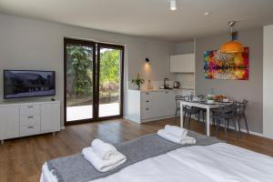 a bedroom with a bed and a kitchen with a table at Sun & Sport Apartamenty Krynica-Zdrój in Krynica Zdrój