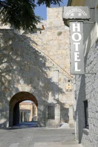 an entrance to a stone building with an archway at Hotel Arco San Vicente in Ávila