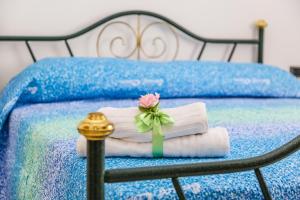 a bed with a pile of towels and a rose on it at Terra Mia in Agerola