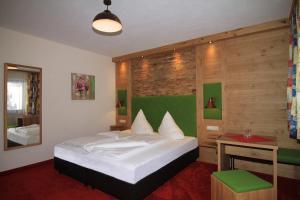a bedroom with a bed and a wooden wall at Hotel Garni Pradella in Ischgl