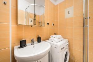 a bathroom with a sink and a washing machine at Sea Flats - Studio in Sopot