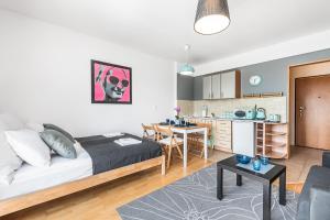 a bedroom with a bed and a kitchen with a table at Sea Flats - Studio in Sopot +2 photos