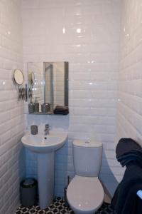 a white bathroom with a toilet and a sink at 2 Minutes from Drumcondra Station in Dublin
