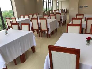 a dining room with white tables and chairs at Windy Hotel Quang Binh in Dong Hoi