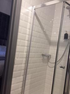 a shower with a glass door in a bathroom at 2 Minutes from Drumcondra Station in Dublin