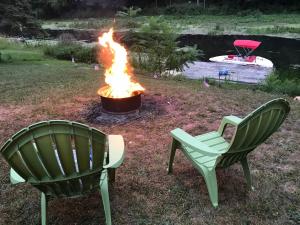 duas cadeiras e uma fogueira num quintal em Serene Port Bay Cottage em Red Creek