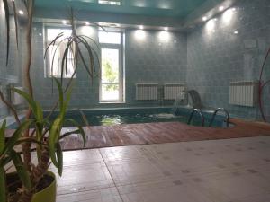 a bathroom with a pool with a potted plant at Дом у моря с бассейном и сауной in Odesa +64 photos