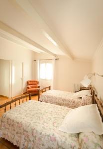 a bedroom with two beds and an orange chair at La Cadière in Lauris