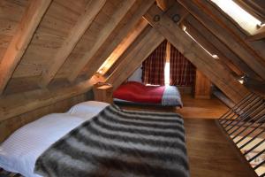 a attic room with a bed and a window at VAUJANYLOCATIONS - Chalets Clovis I & II in Vaujany