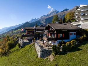 a house sitting on top of a green hill at Casa Vesta Magnifica Wildi in Breil/Brigels