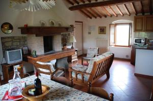 a living room with a fireplace and a table with chairs at Due Piani in Barberino di Val dʼElsa