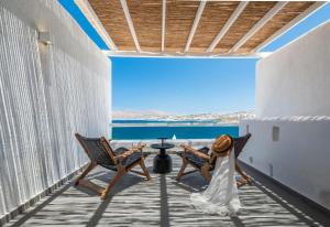 a woman in a wedding dress sitting in chairs on a balcony at Dreambox Mykonos Suites and Mini Villas in Ornos