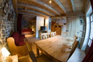 a dining room with a wooden table and a couch at VAUJANYLOCATIONS - Chalets Clovis I & II in Vaujany