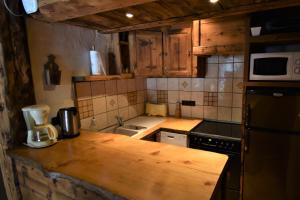 a kitchen with a wooden counter top with a microwave at VAUJANYLOCATIONS - Chalets Clovis I & II in Vaujany +27 photos