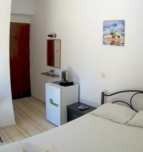 コントカリにあるPila Apartmentsのベッド1台、小型冷蔵庫が備わる客室です。