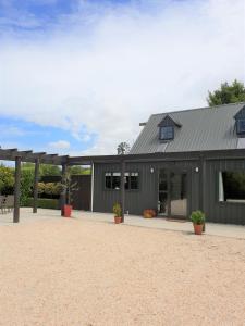 a gray barn with a metal roof at Accommodation at Lakeside in Oamaru