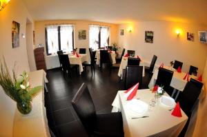 a restaurant with tables and chairs in a room at Hotel Gema in Braşov