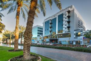 two palm trees in front of a building at City Avenue Hotel in Dubai