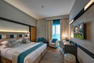 a hotel room with a large bed and a desk at City Avenue Hotel in Dubai