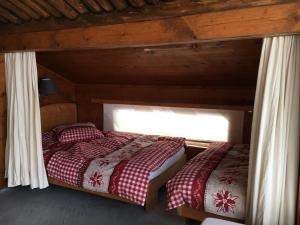 two twin beds in a room with a window at Casa Vesta Magnifica Wildi in Brigels