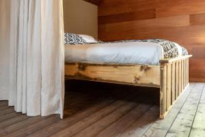 a bed in a room with a wooden wall at bnb De Loft in Kloosterzande
