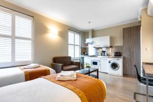 ein Hotelzimmer mit 2 Betten und einer Küche in der Unterkunft SW1 Apartments in London