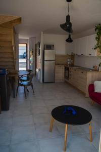 cocina y sala de estar con mesa en Les Terrasses de Bella Vista - Belle maison bord de mer, en Saint-Vincent-sur-Jard