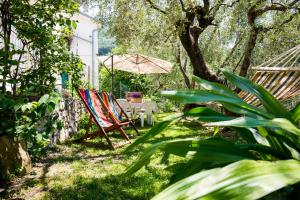 einen Garten mit einem Tisch, Stühlen und einem Sonnenschirm in der Unterkunft Uliveto in Diano San Pietro