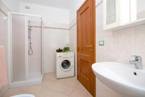a bathroom with a washing machine and a sink at Uliveto in Diano San Pietro