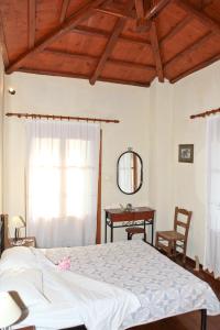 sypialnia z łóżkiem, stołem i lustrem w obiekcie Villa Maria O w mieście Skopelos