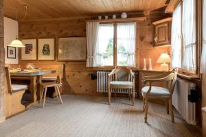 - une chambre avec une table et des chaises dans une maison en bois dans l'établissement Casa Vesta Magnifica Wildi, à Brigels