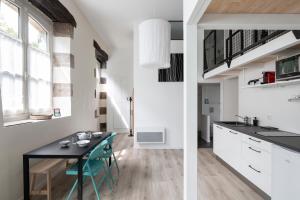 una cucina e una sala da pranzo con tavolo e sedie di L'instant - Appt climatisé pour 4 , centre Rennes a Rennes