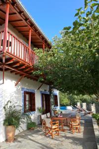 patio ze stołem i krzesłami przed domem w obiekcie Villa Maria O w mieście Skopelos