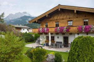 une grande maison en bois avec des fleurs sur le balcon dans l'établissement Appartement Lorenz, à St. Johann in Tirol