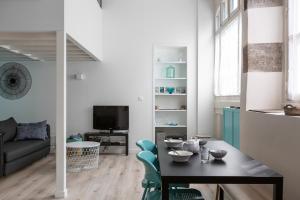 un soggiorno con un tavolo e sedie in una stanza di L'instant - Appt climatisé pour 4 , centre Rennes a Rennes Altre 3 foto
