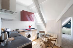 a kitchen with a sink and a table with chairs at Saint Germain RENNES by Cocoonr in Rennes