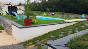 a pool with chairs and a potted plant in a yard at Alolival in Sablonceaux