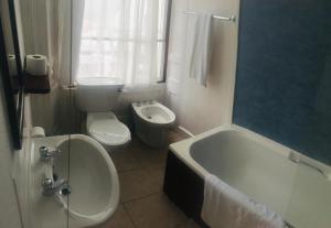 a bathroom with a tub and a toilet and a sink at The White Hart Hotel in Hayle