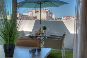 d'une table, de chaises et d'un parasol sur le balcon. dans l'établissement O Carré Croisette Cannes, à Cannes